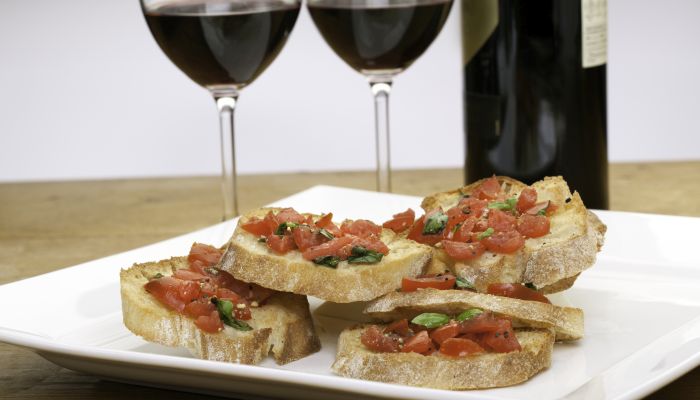 Opções de petiscos para comer com vinho: bruschetta de tomate